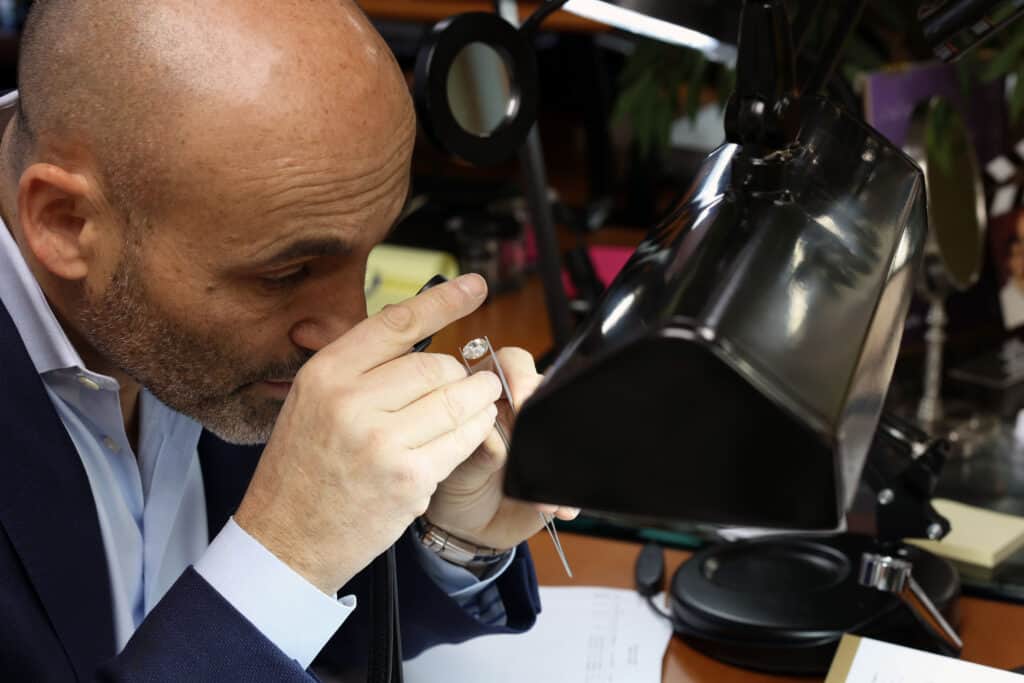 Eric Mor is inspecting diamonds with a loupe