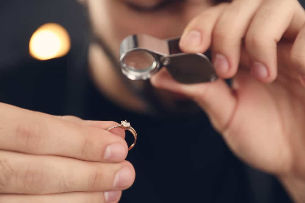 examining a diamond ring under a loupe