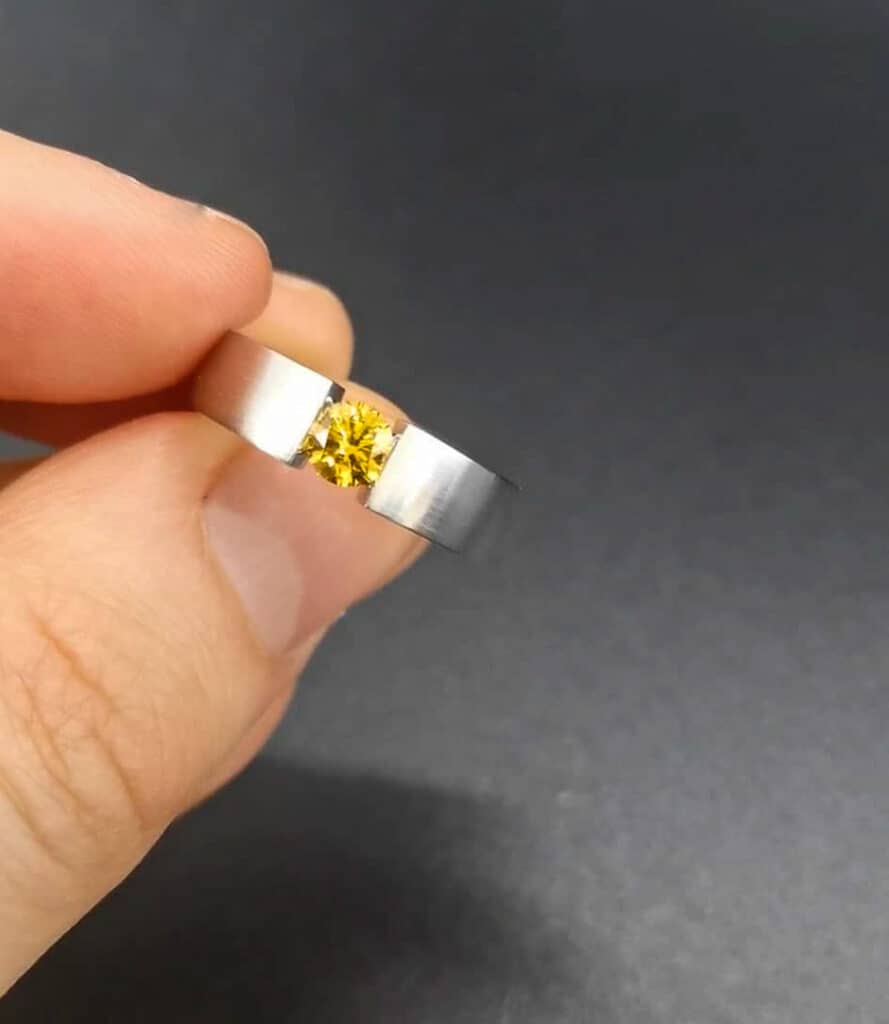 A fancy vivid yellow diamond in a beautiful tension ring by Abe Mor